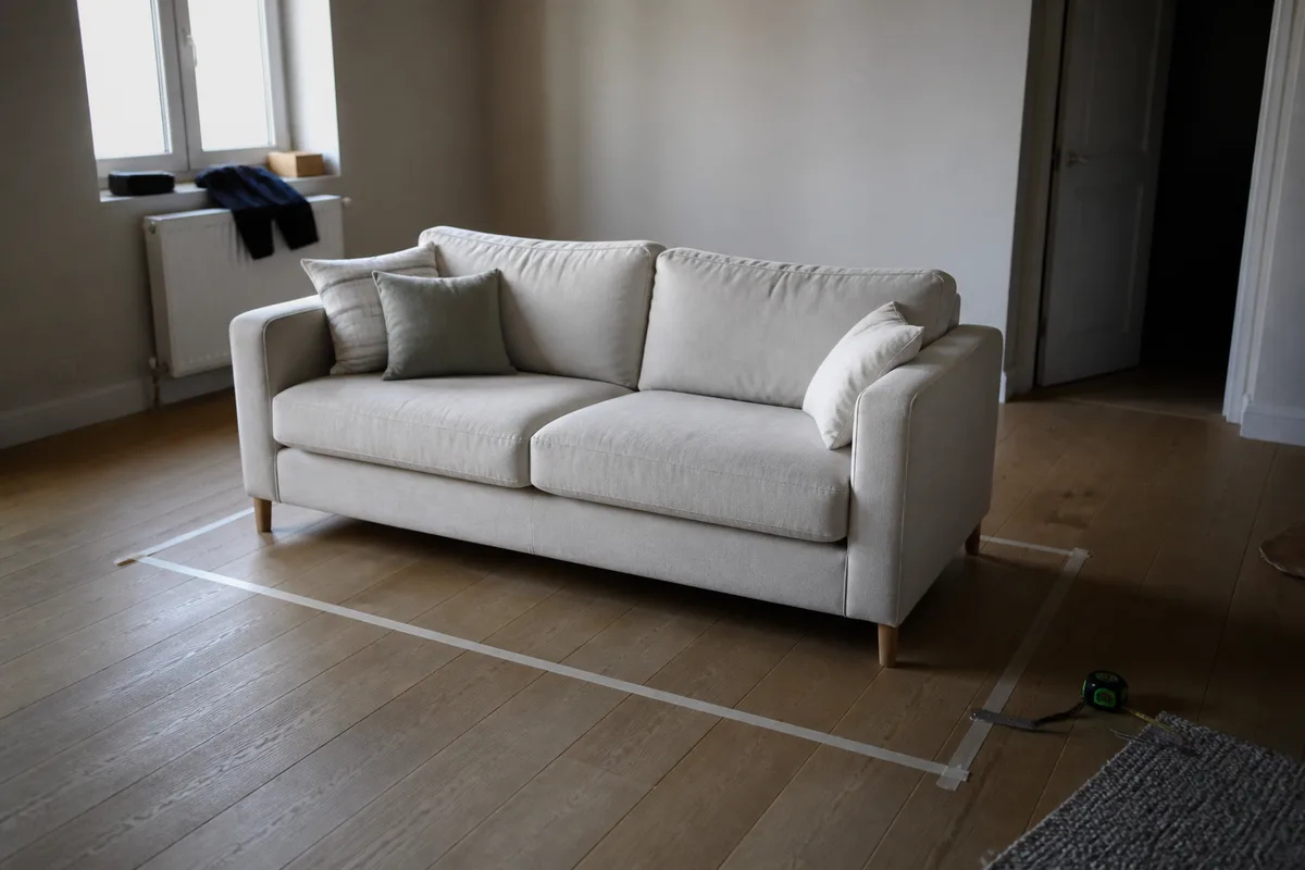 Canapé Maisons du Monde en tissu dans un salon lumineux, avec espace de circulation autour de l’assise